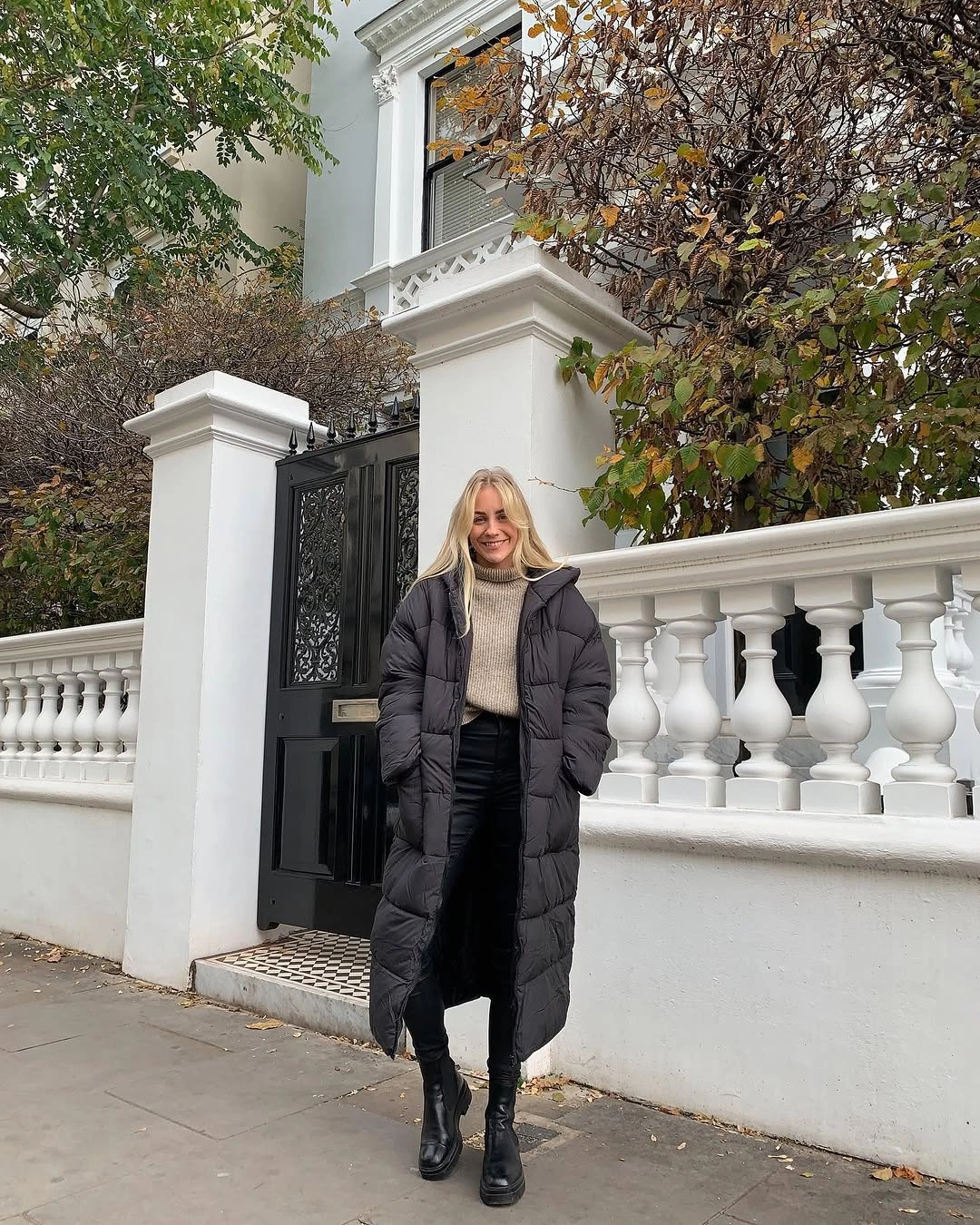 Long charcoal puffer with gray sweater and black boots