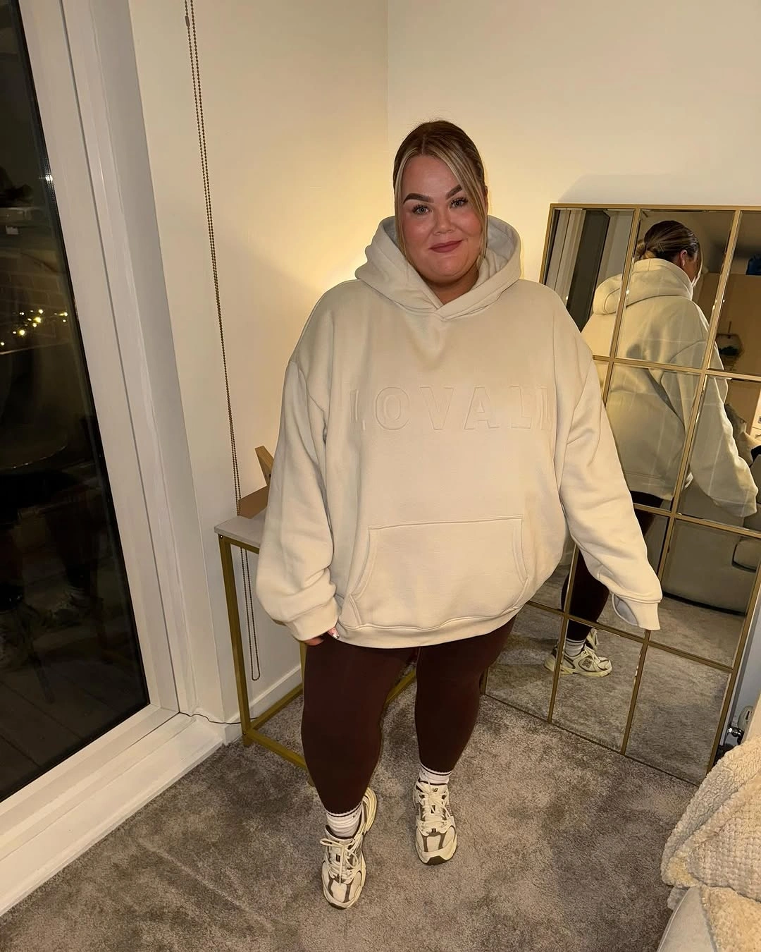 Cream oversized hoodie with brown leggings and sneakers