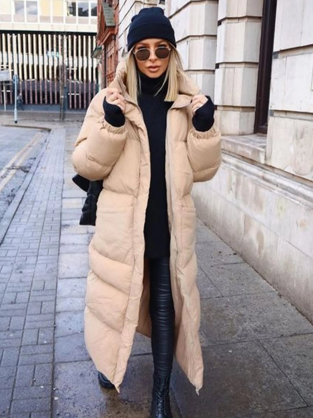 Beige puffer coat over black turtleneck and pants