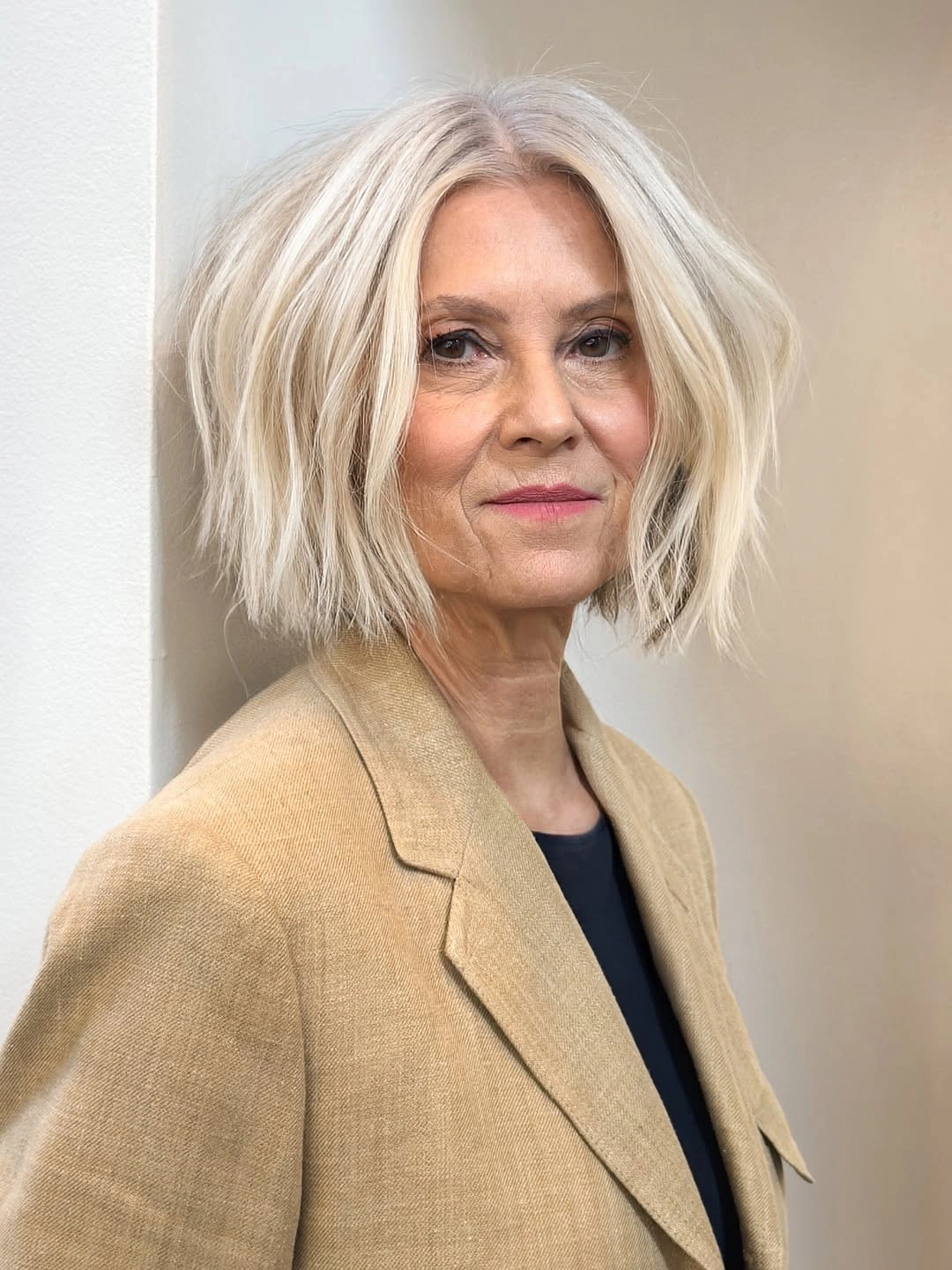 Pale blonde chin-length bob with center part and tousled bends