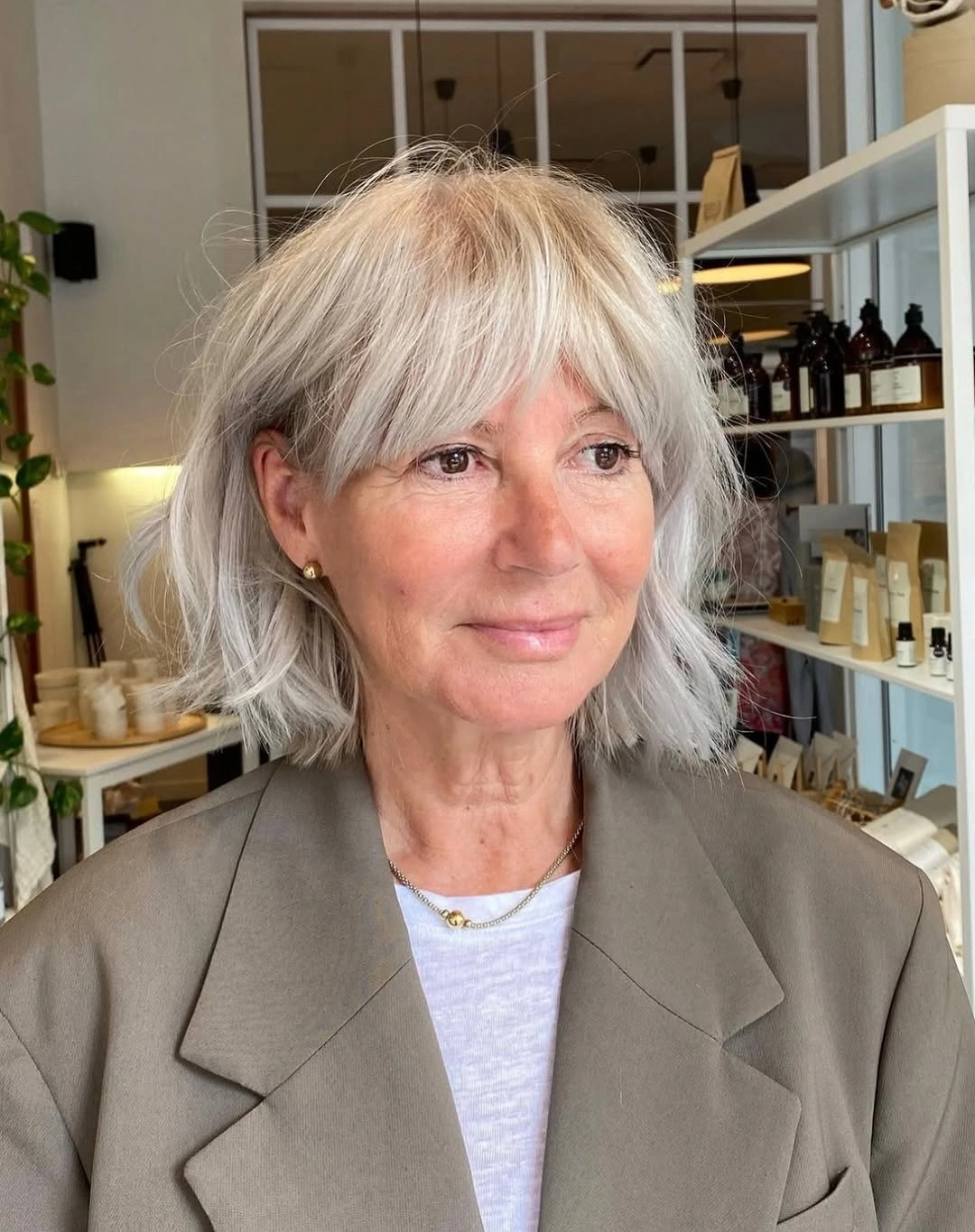 Silver shoulder-length bob with airy bangs and softly bent ends