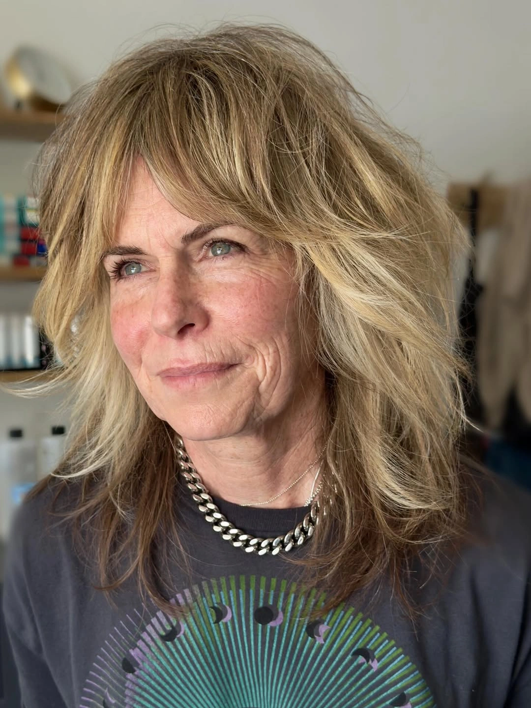 Blonde layered haircut with curtain fringe and feathered face-framing pieces