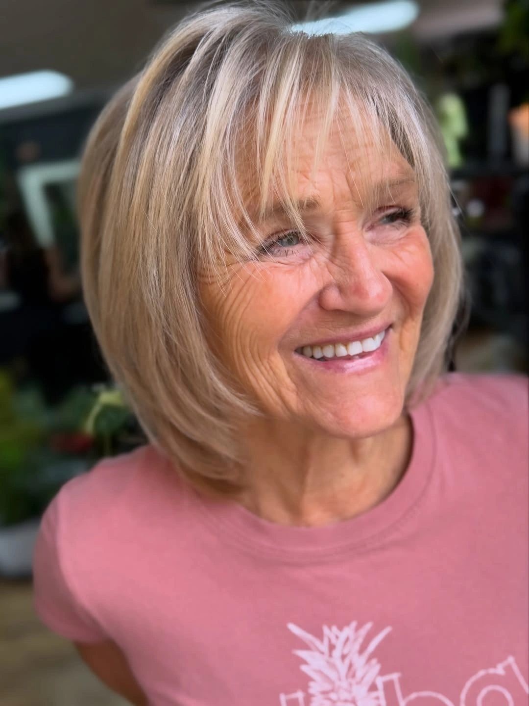 Warm blonde chin-length bob with wispy bangs and curved ends