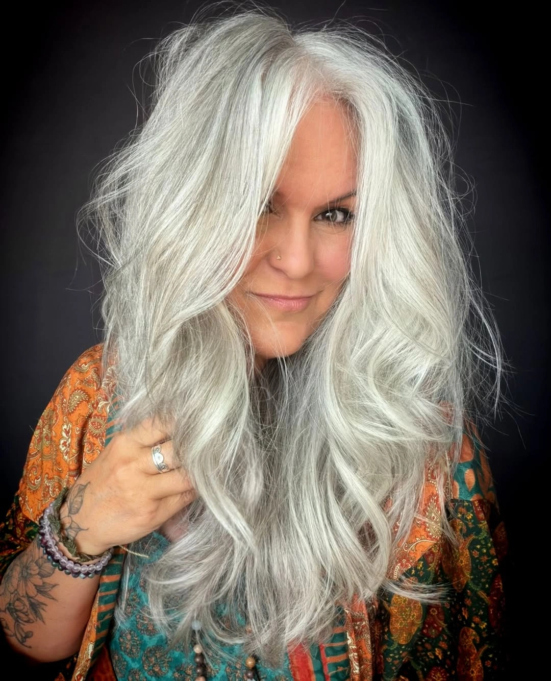 Long silver layered haircut with loose waves and face-framing pieces