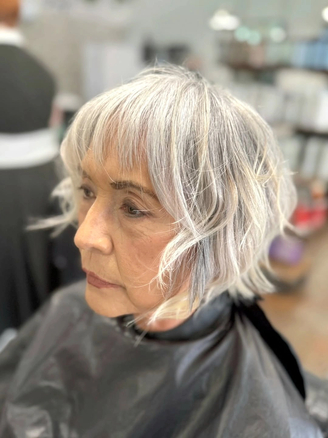 Choppy silver bob with wispy bangs and flipped ends