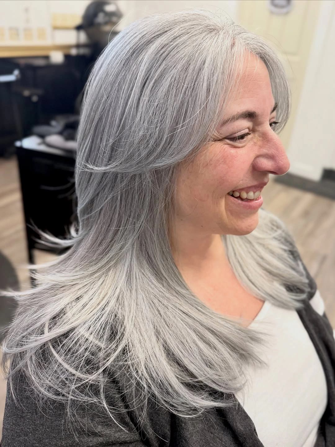 Long silver layered haircut with center part and feathered ends