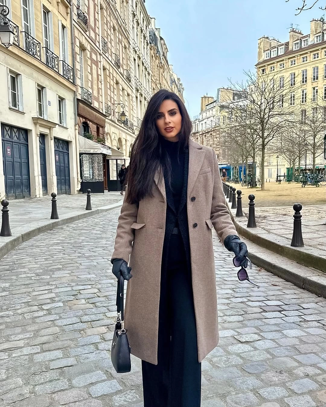 Woman in taupe coat over black outfit