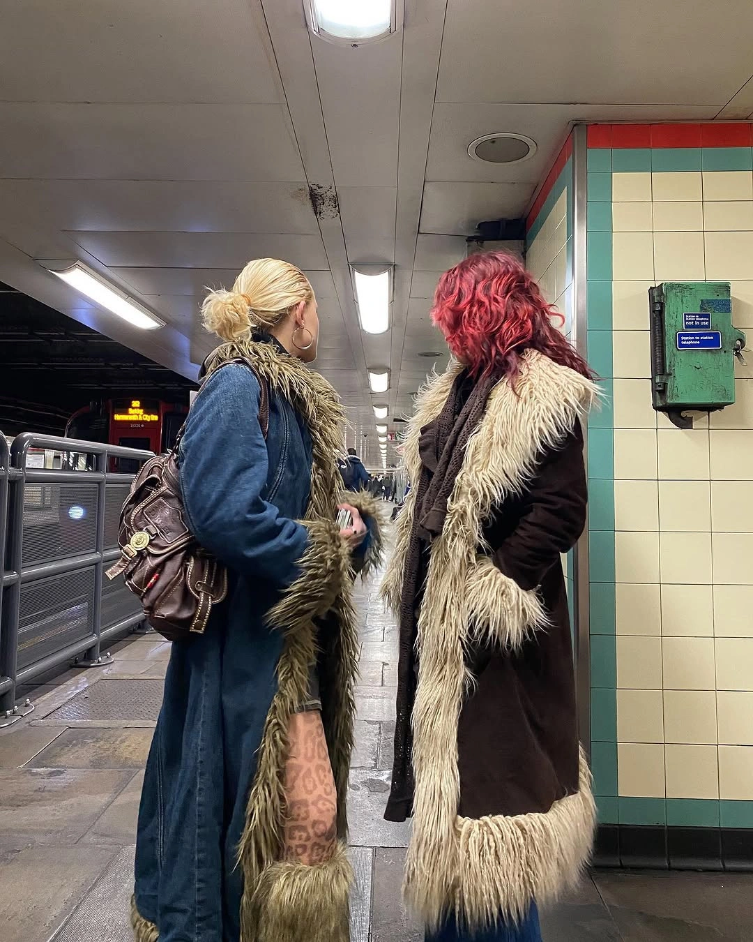 Two long coats with contrasting shaggy trim in station