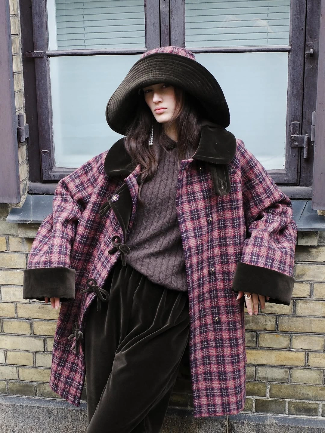 Pink burgundy plaid coat with black trim and wide hat