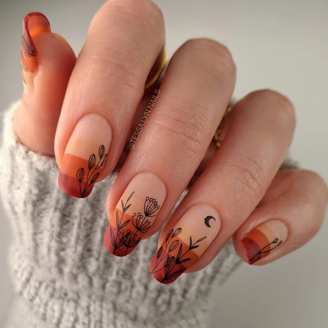 Almond nails with orange red tips and black botanical drawings