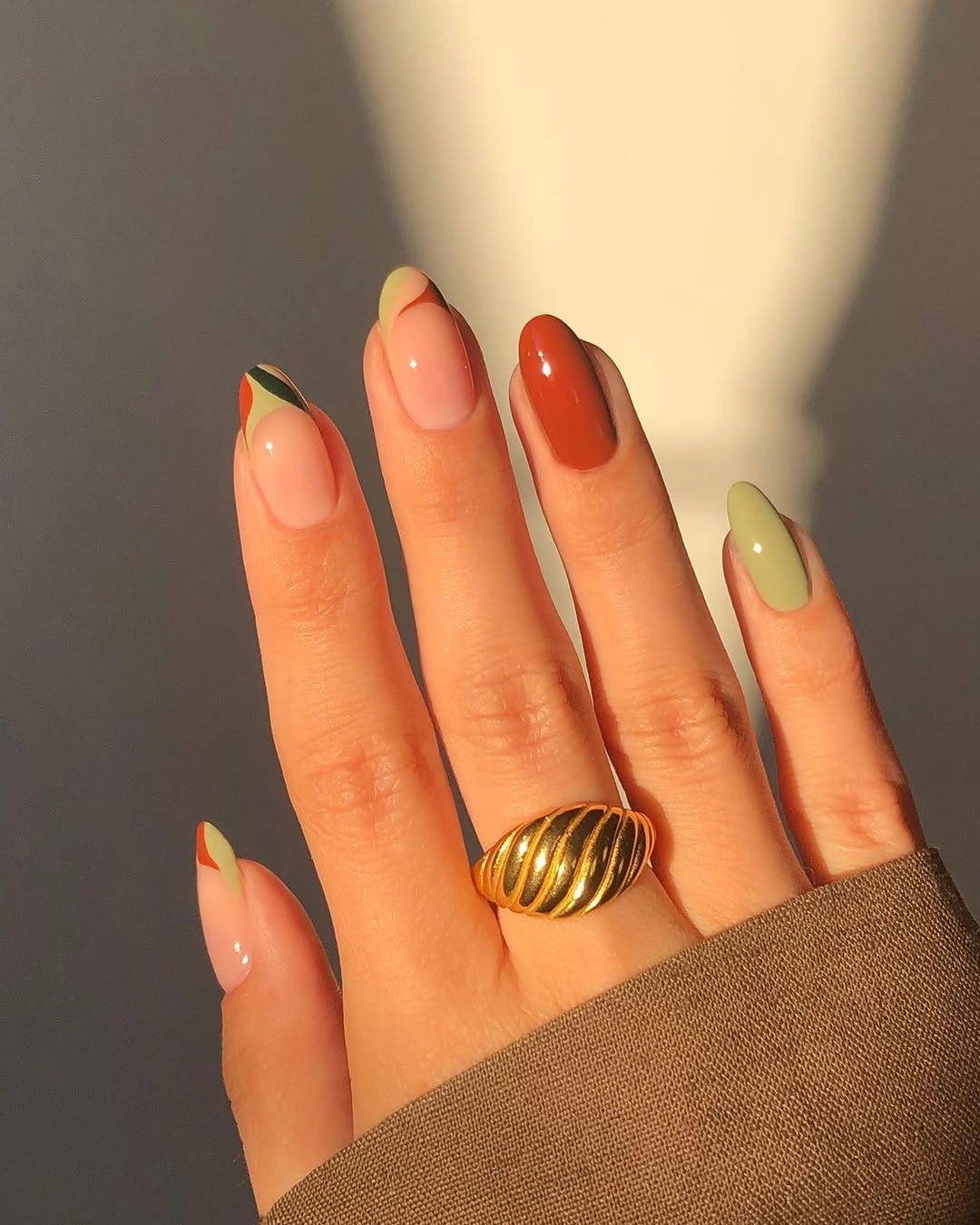 Sheer peach almond nails with green orange and yellow tips