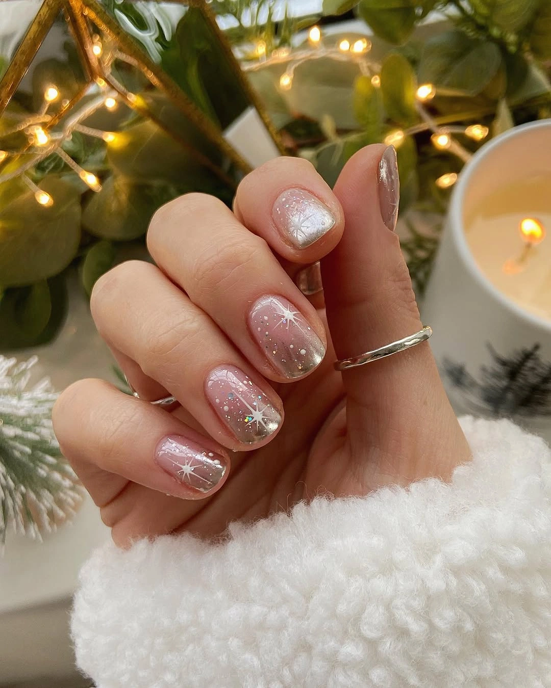 Sheer pink nails with white starbursts and glitter
