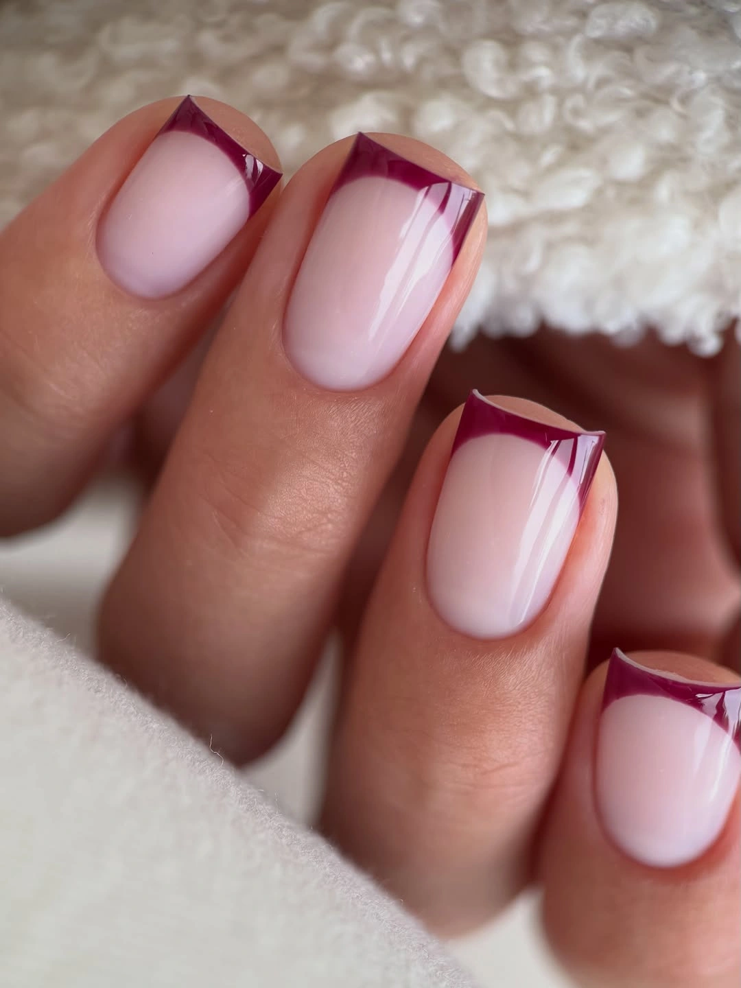 Pale pink nails with angular burgundy French tips