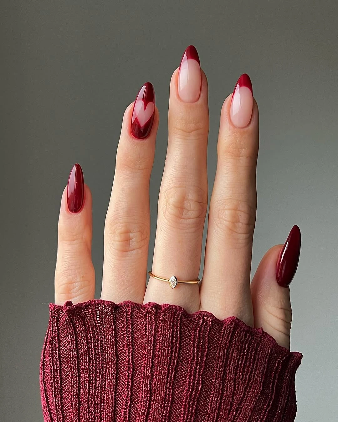 Burgundy almond nails with nude negative-space tips