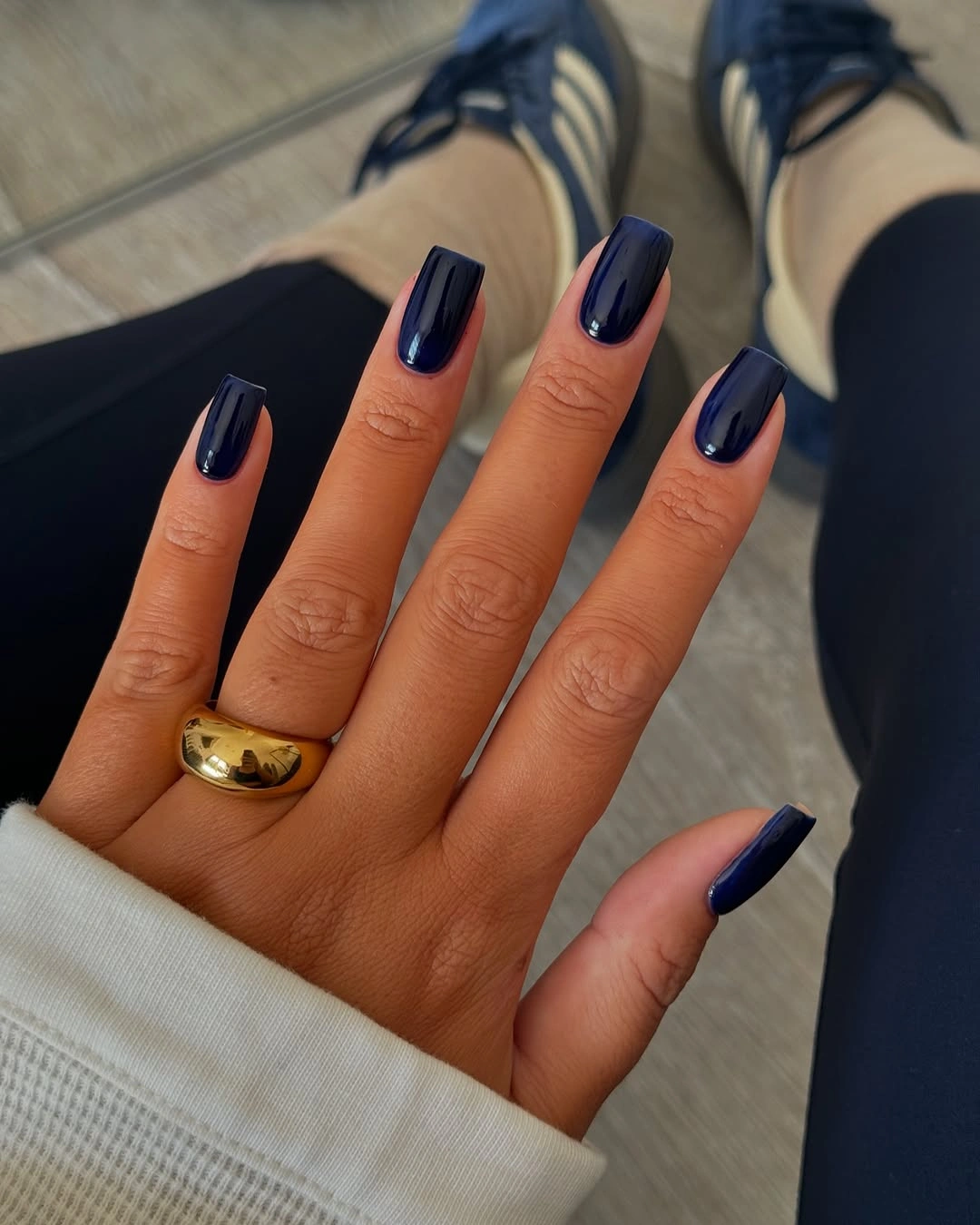 Short glossy navy nails with white sleeve and sneakers