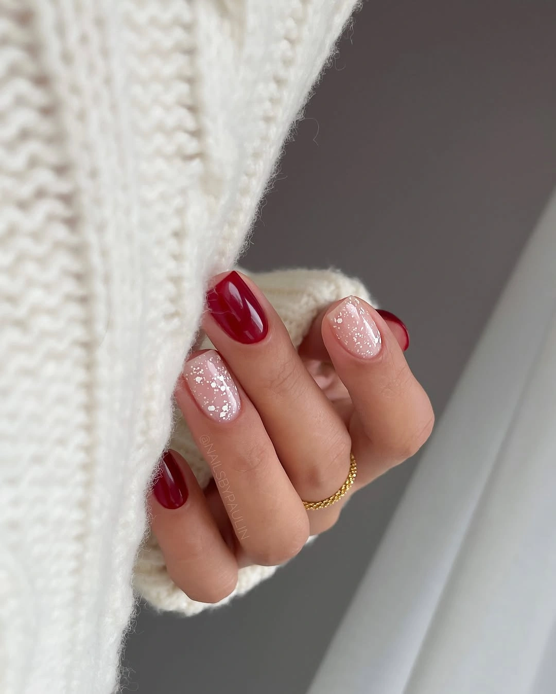 Short red nails with pale pink glitter accents