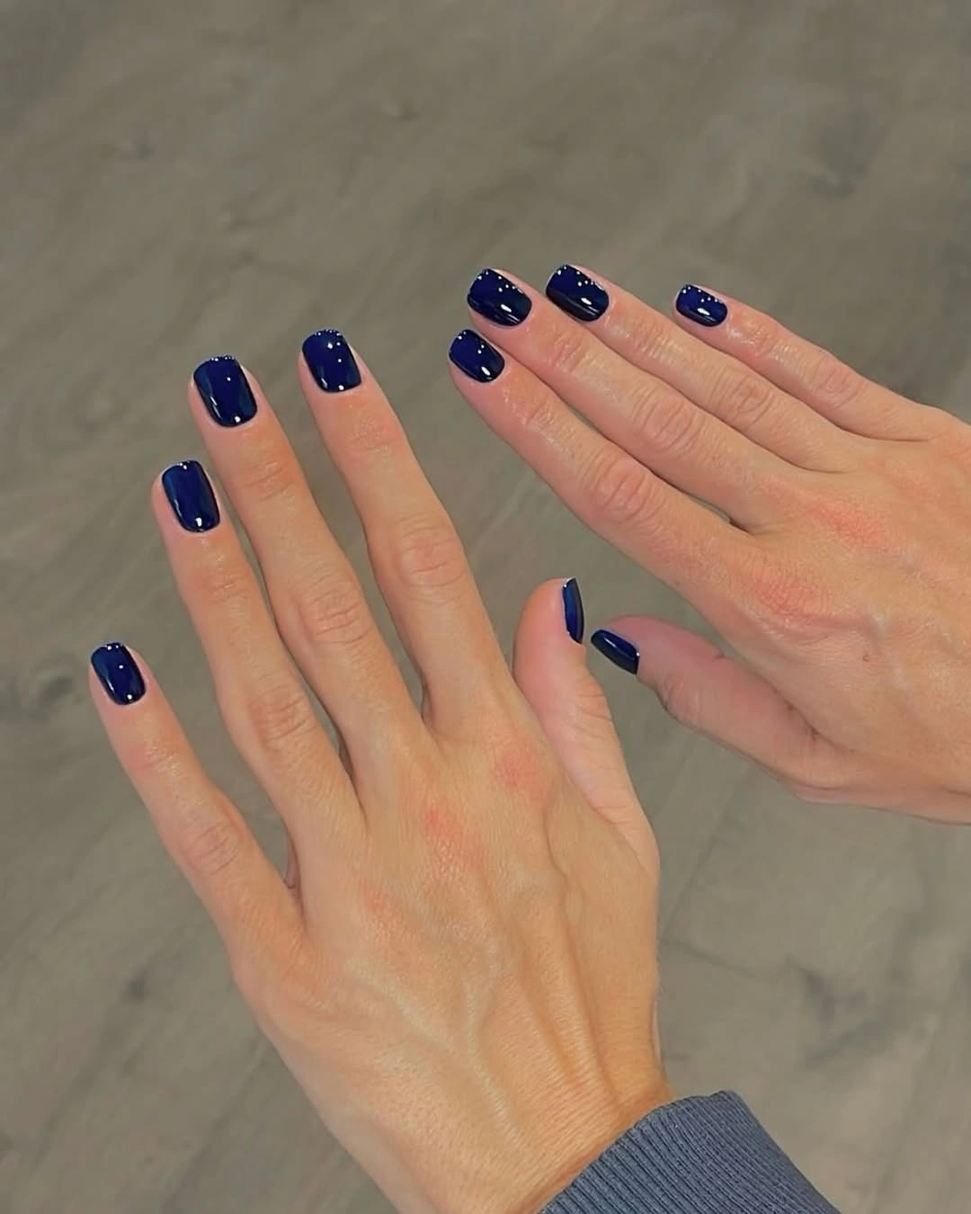 Short glossy navy nails on both hands