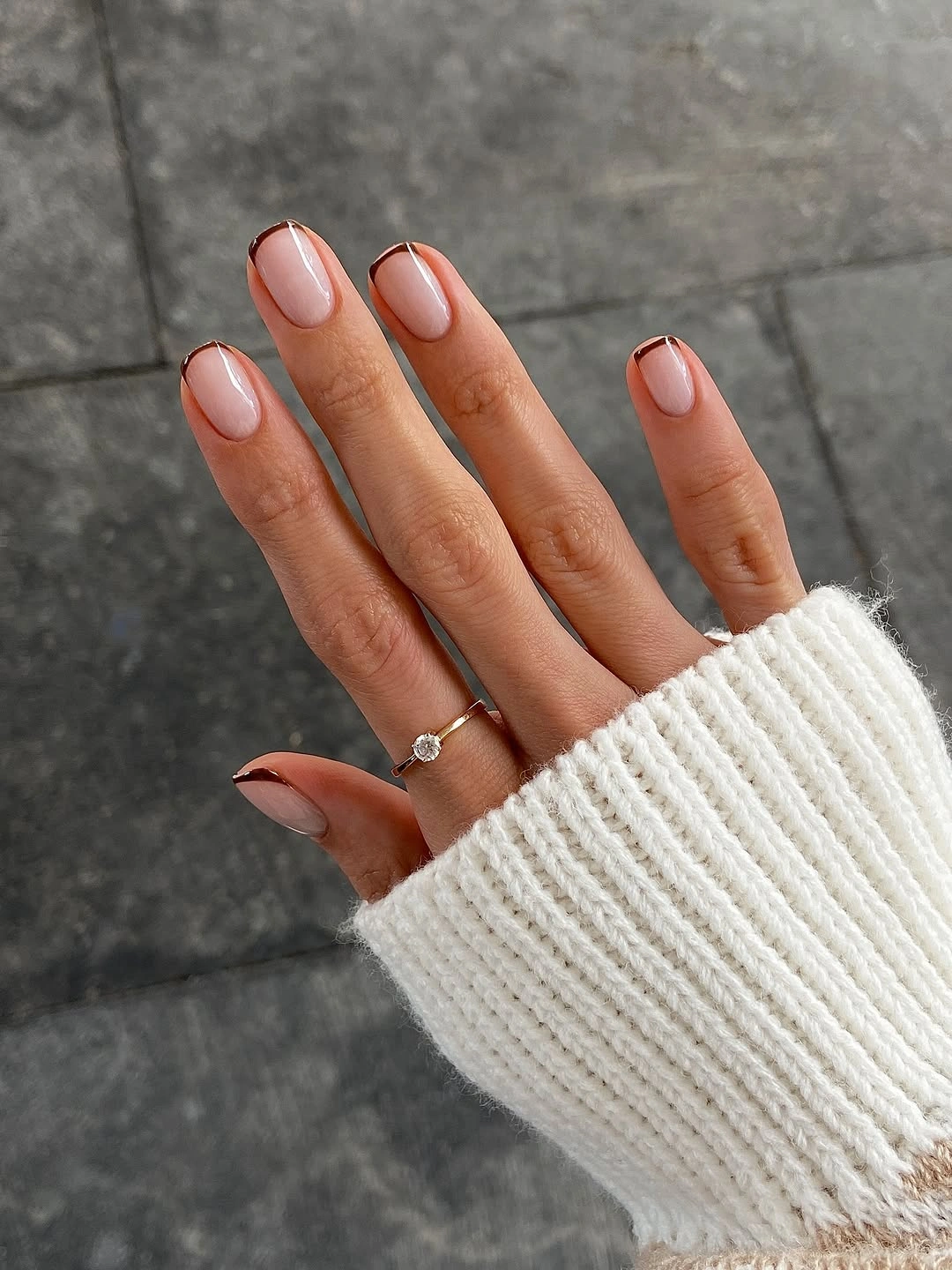 Short nude-pink nails with thin burgundy French tips