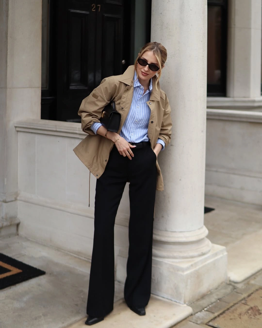 Tan jacket blue striped shirt black flared trousers and pointed shoes
