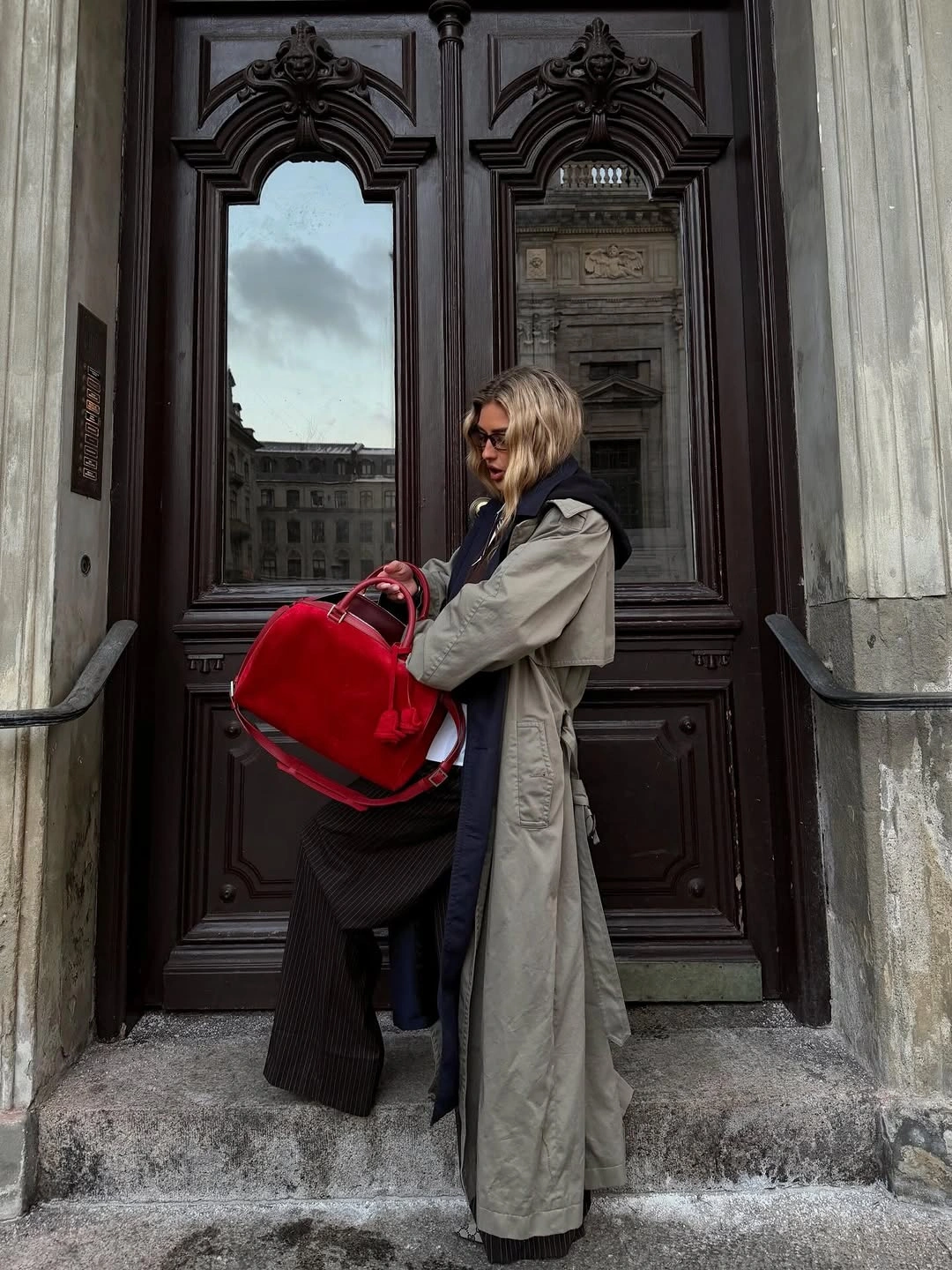 Long olive coat dark lower layer and large red bag