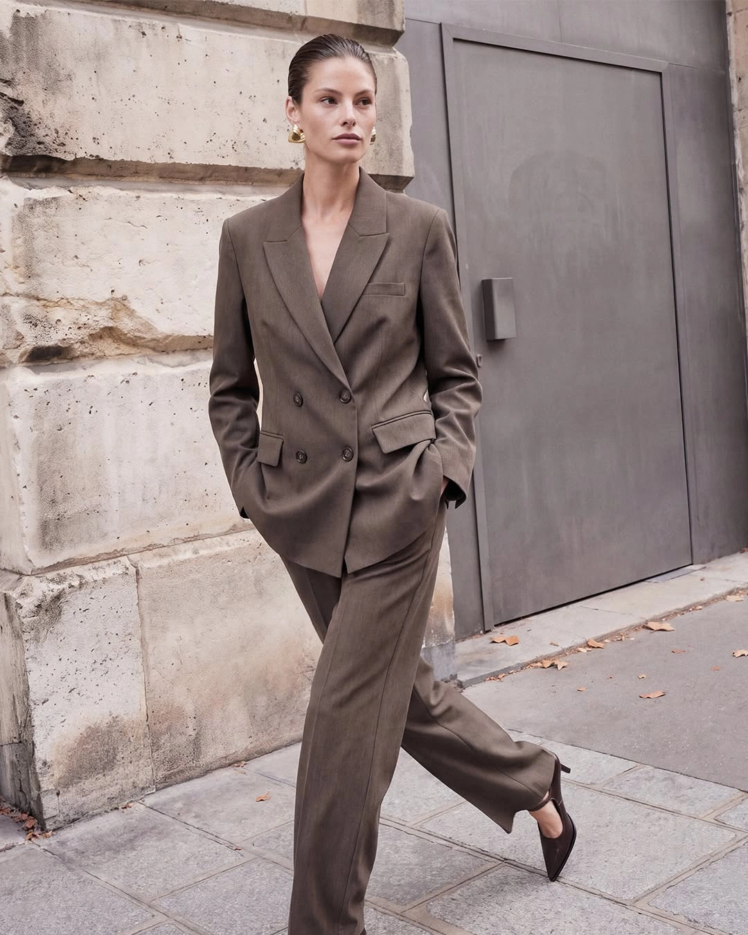 Taupe double-breasted blazer matching trousers and black slingback shoes
