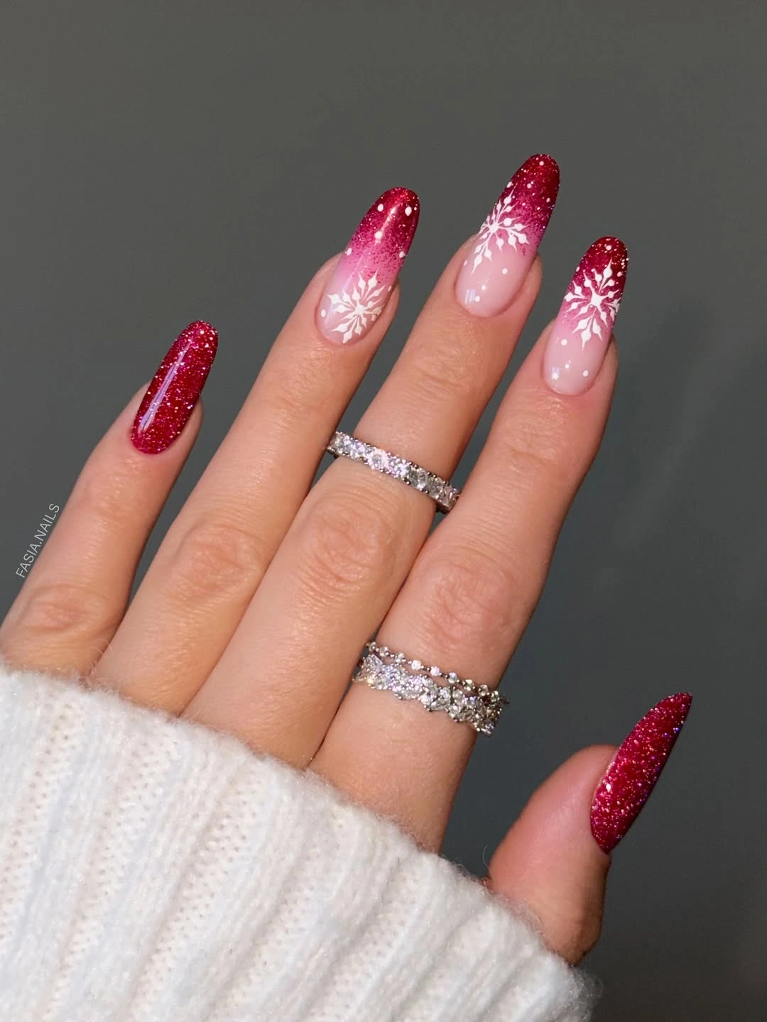 Long red glitter nails with pink bases and white snowflakes