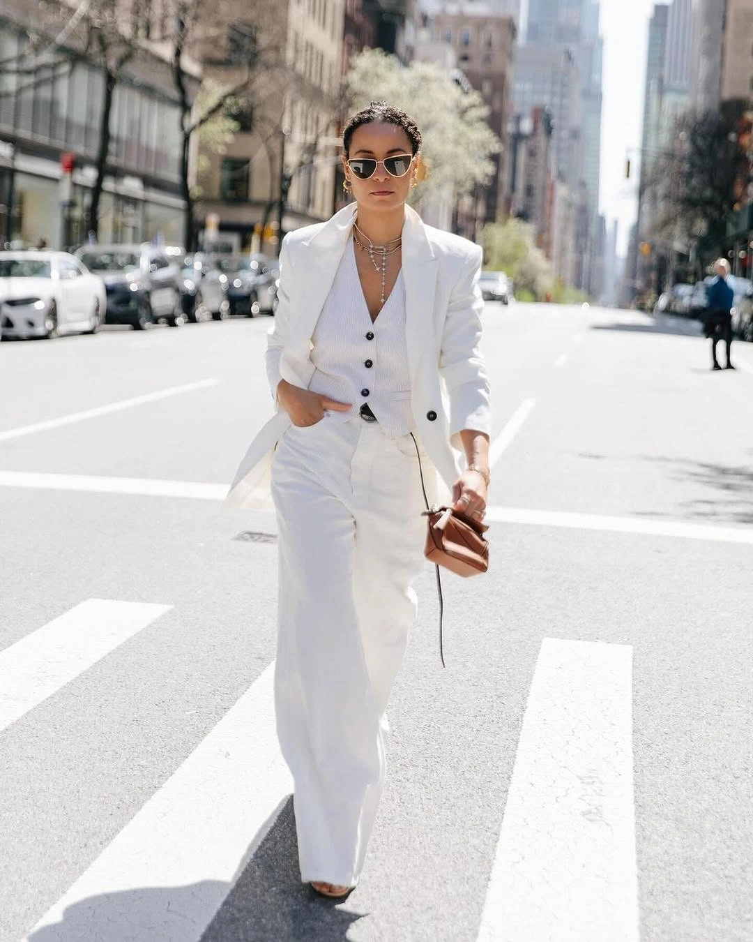 White blazer trousers and buttoned vest with layered necklaces