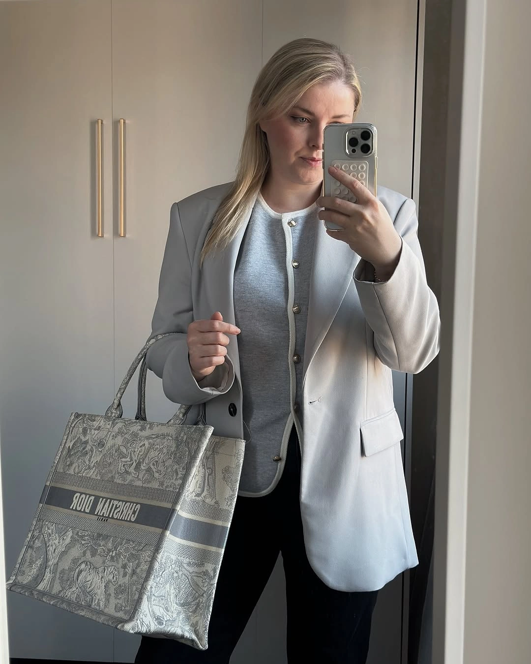Light gray blazer buttoned gray layer black trousers and patterned tote