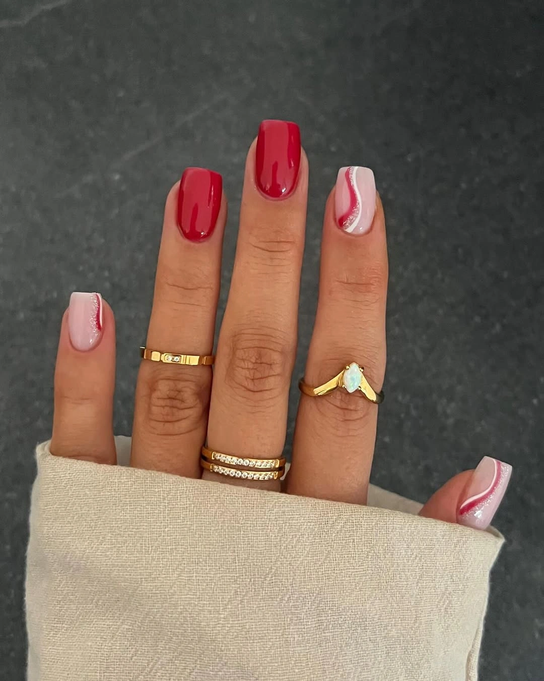 Short square red nails with pink accents and curved lines