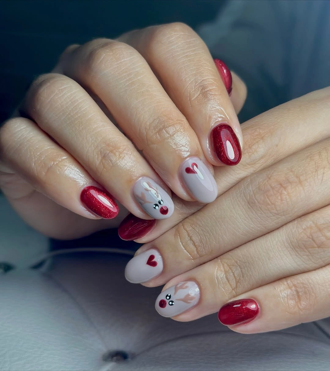 Short burgundy nails with pale reindeer accents and red hearts