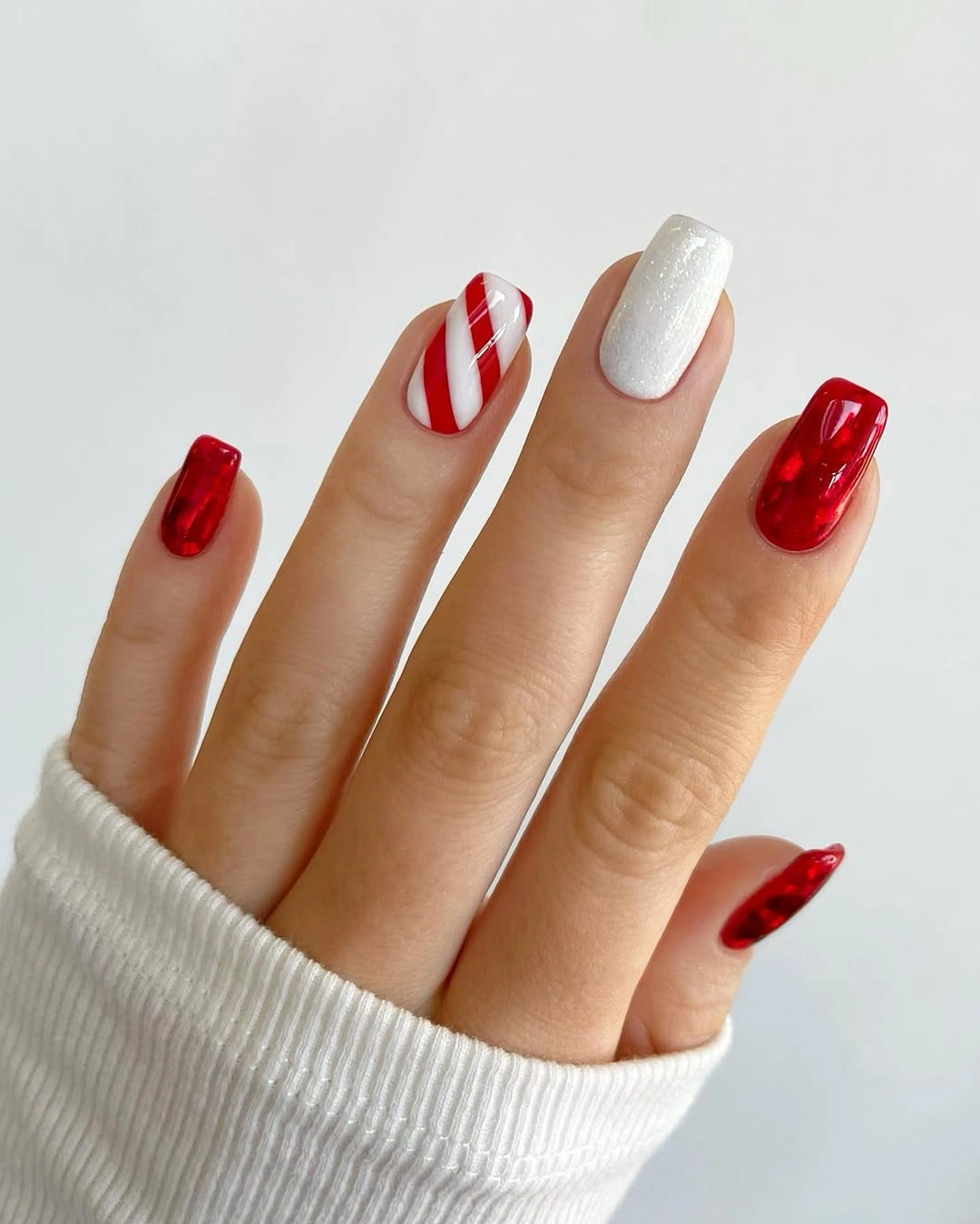 Red and white nails with candy stripe and pearly accent