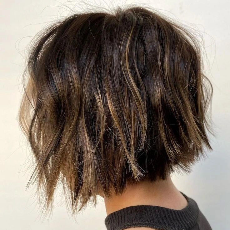 Short brunette bob with tousled ends and narrow lighter highlights