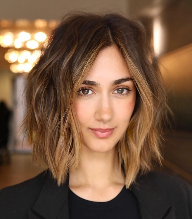 Brunette shoulder-length lob with center part and lighter wavy ends