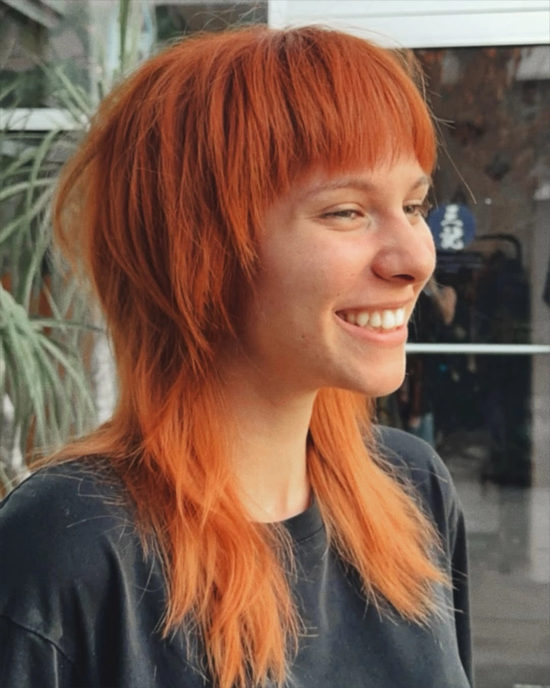 Bright copper-orange shag with blunt fringe and longer tapered sections
