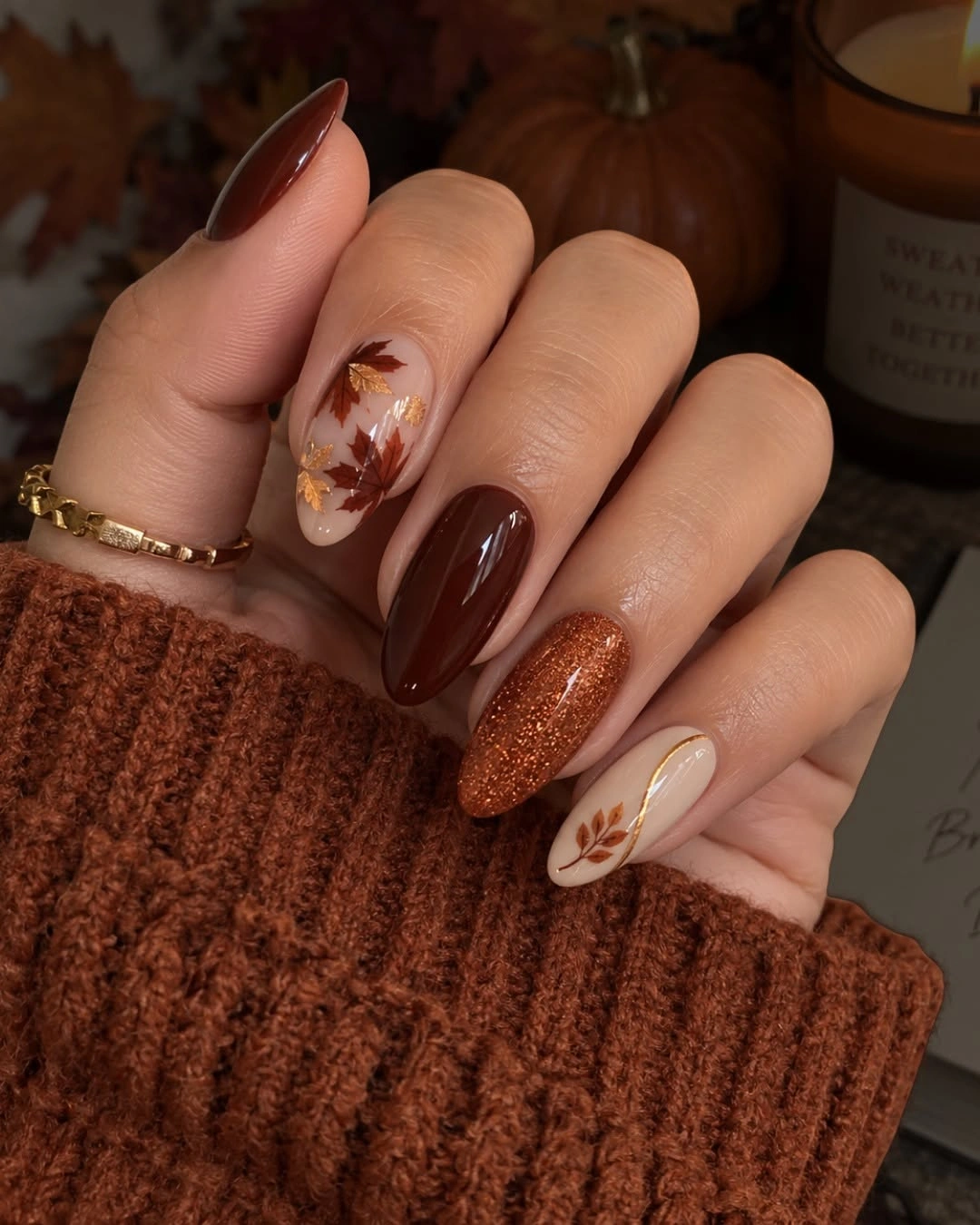 Almond nails with chocolate brown, nude leaf art and copper sparkle