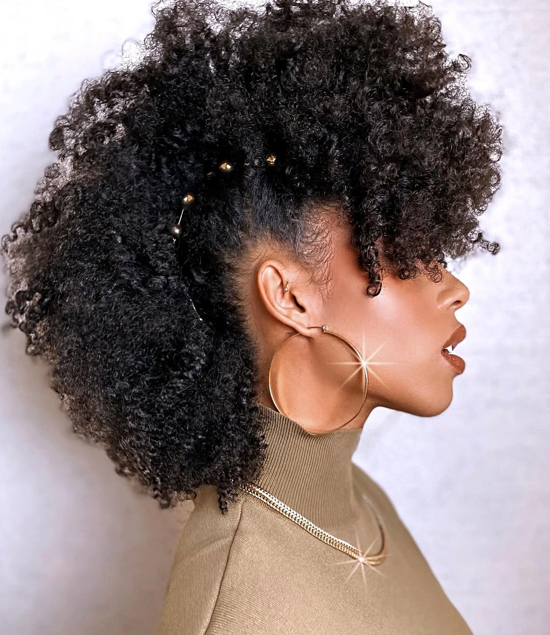 High black curls with tapered side and gold hair accents