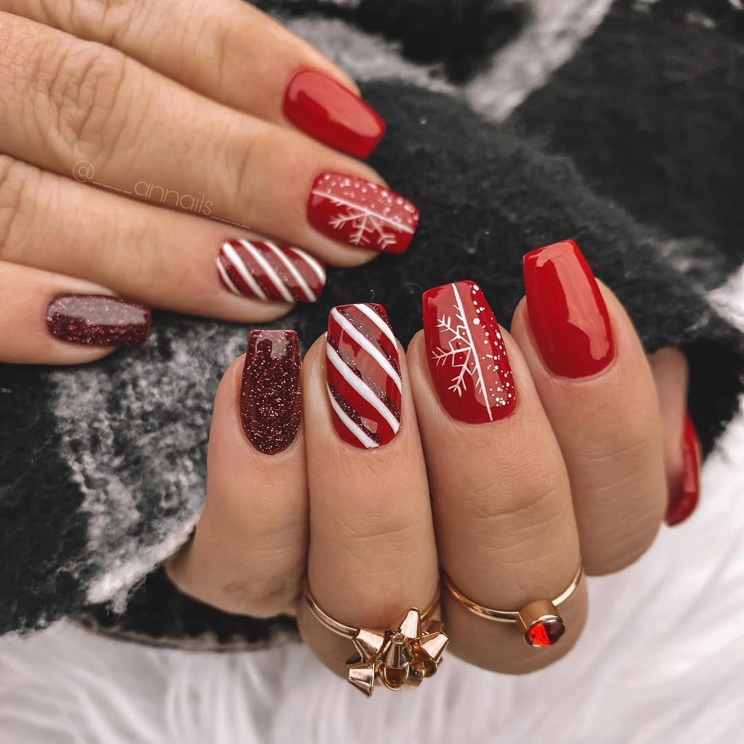 Square red nails with candy stripes and snowflake art