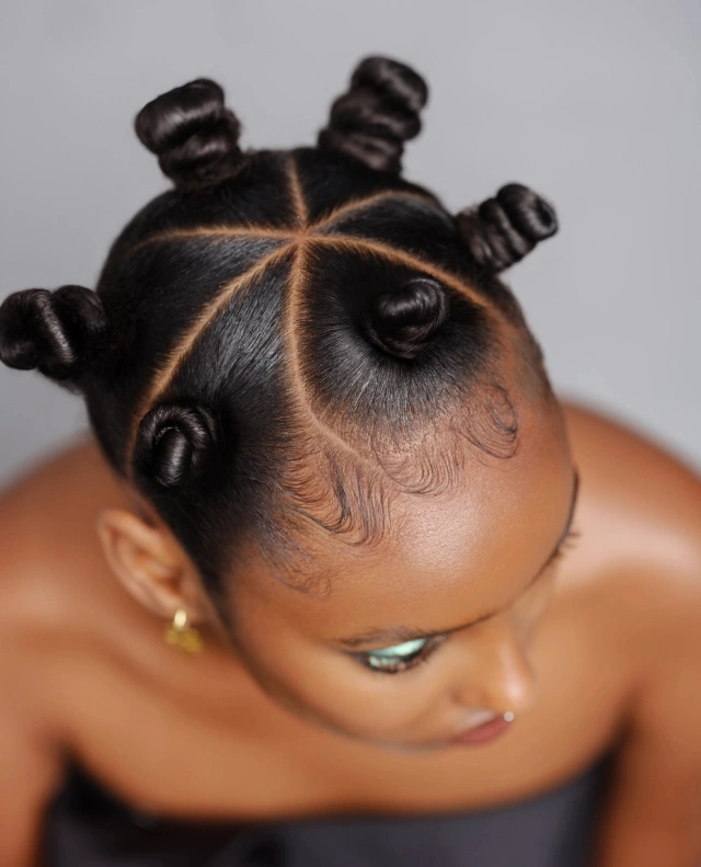 Glossy sectioned hair with clean parting and small coiled buns