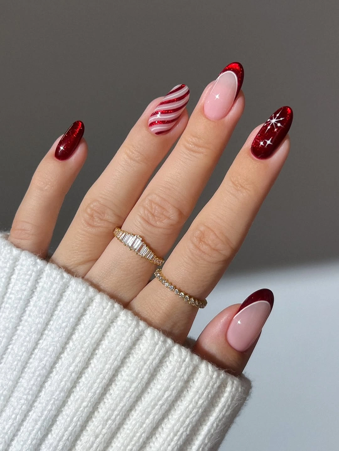 Burgundy almond nails with candy stripe and snowflake accents