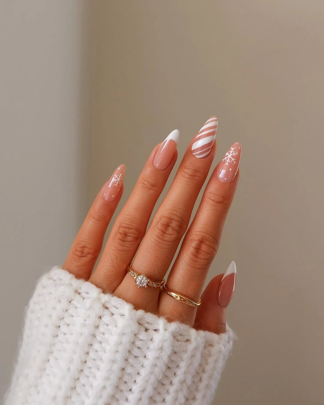 Nude almond nails with white tips and snowflake marks