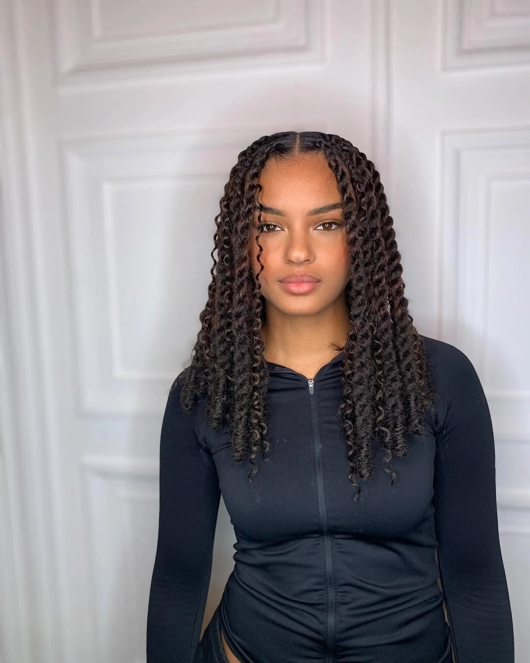 Center-parted long twists with dark zip-front top