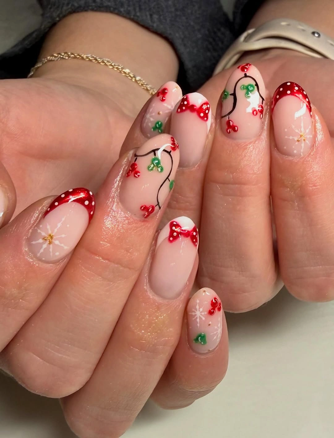 Short nude nails with red tips and tiny bows