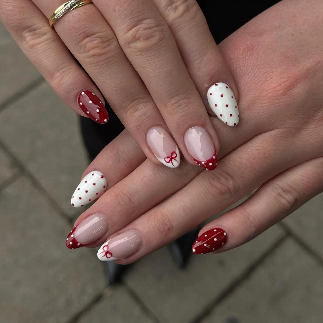 Short rounded nails with red tips bows and polka dots