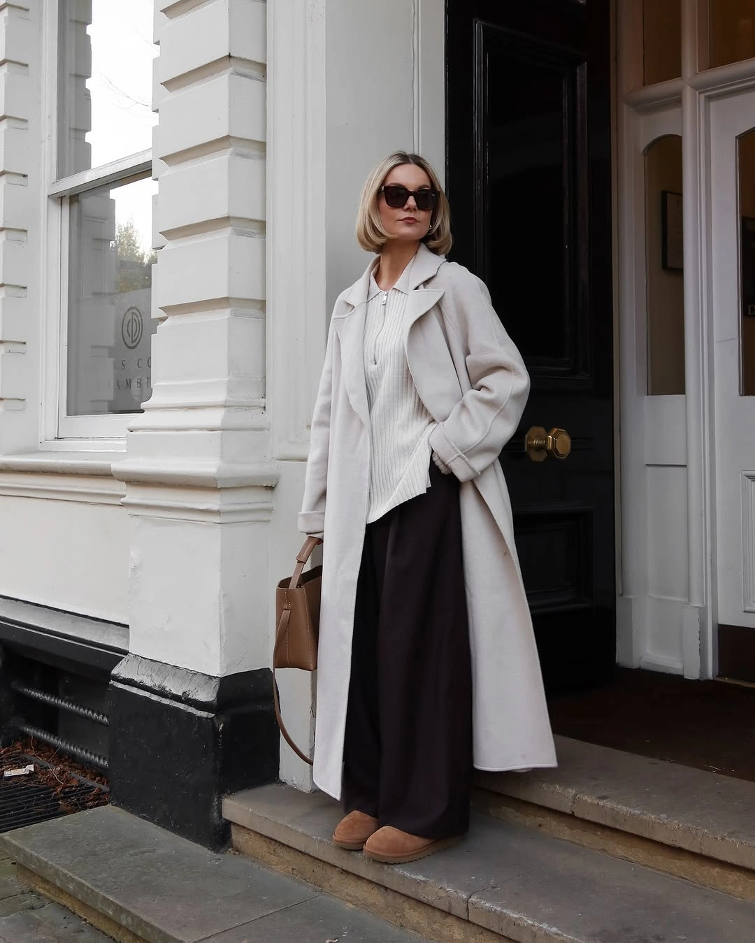 Light long coat with dark lower layer and tan accessories
