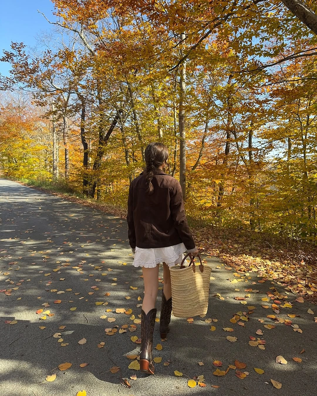 Cropped dark jacket with ruffled white hem and brown boots