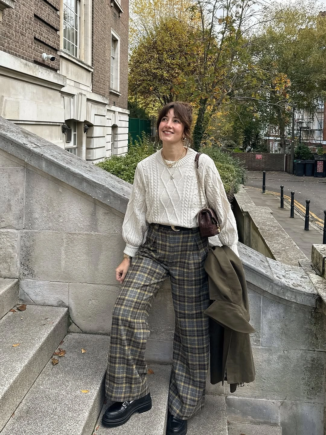 Cream cable sweater with wide plaid trousers and black shoes