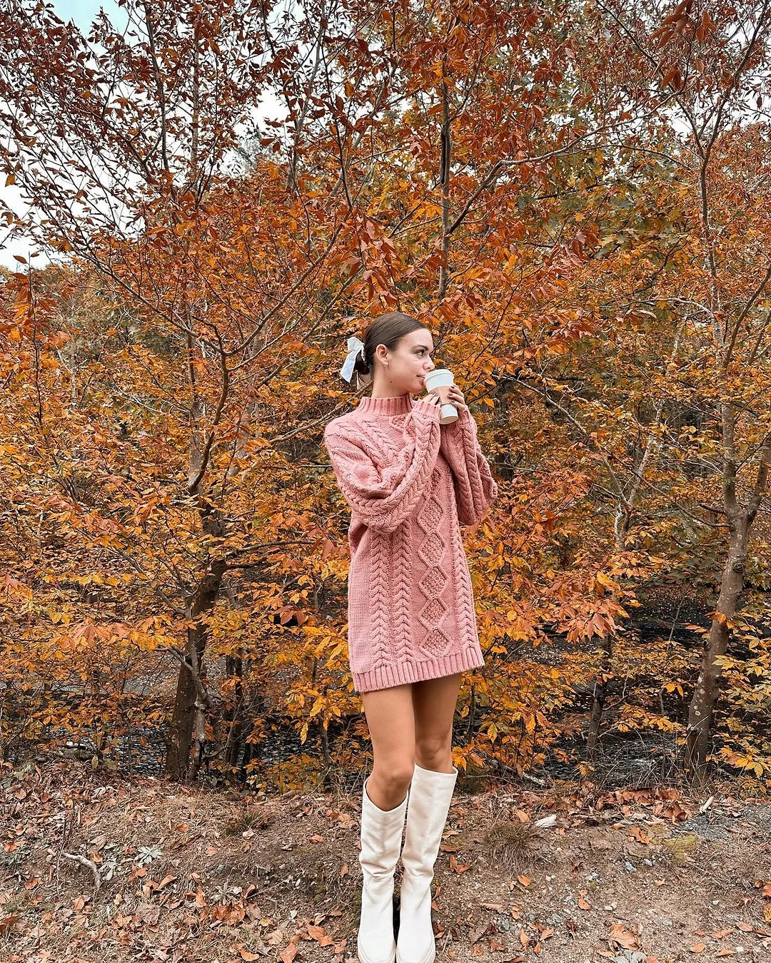 Oversized pink cable knit with white knee-high boots