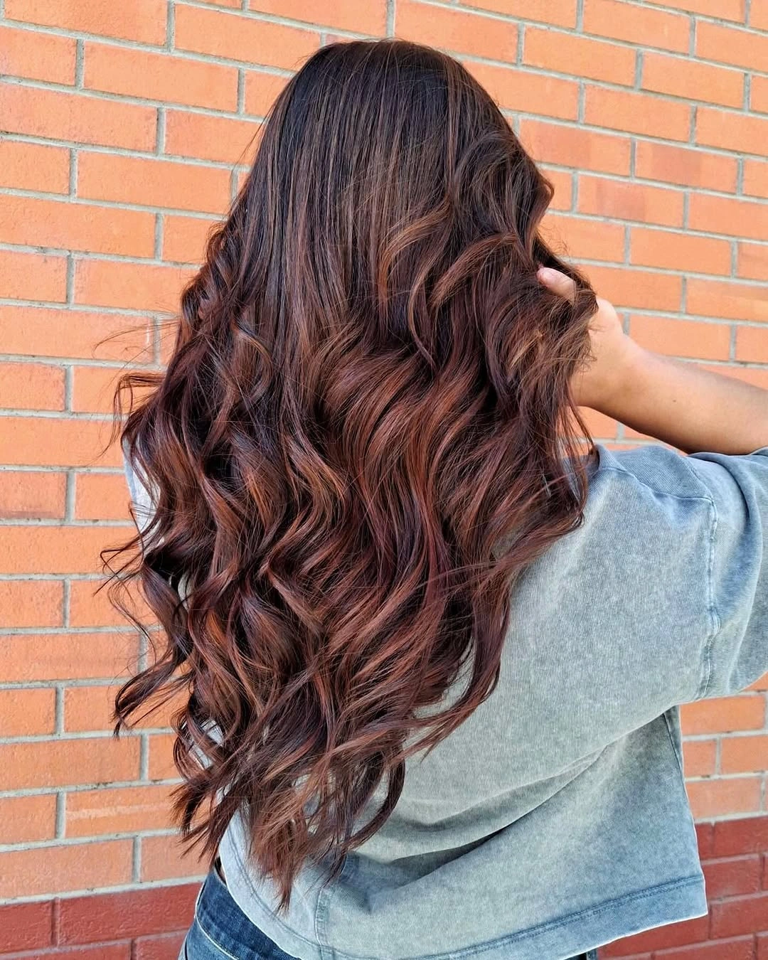 Long dark brunette waves with muted copper-red ribbons