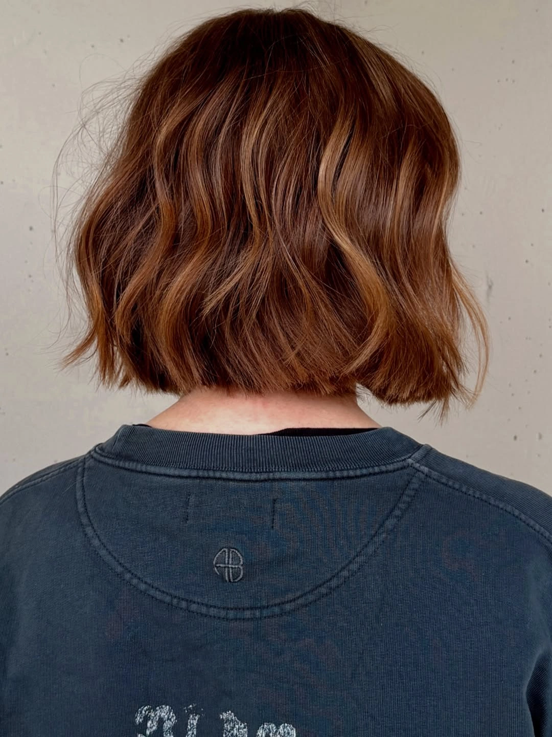 Short wavy auburn bob with deeper brown crown