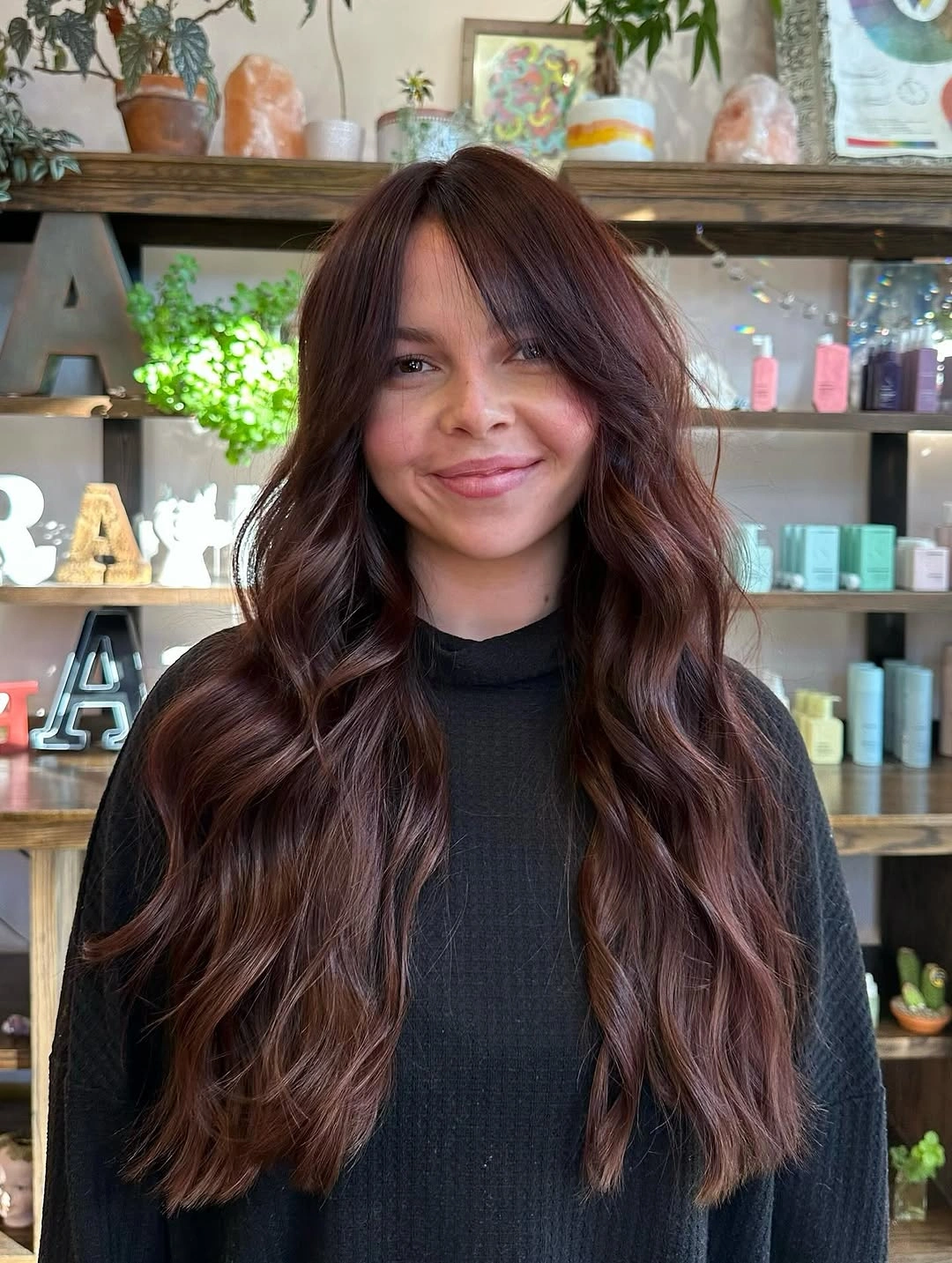 Long mahogany-auburn waves with soft curtain bangs